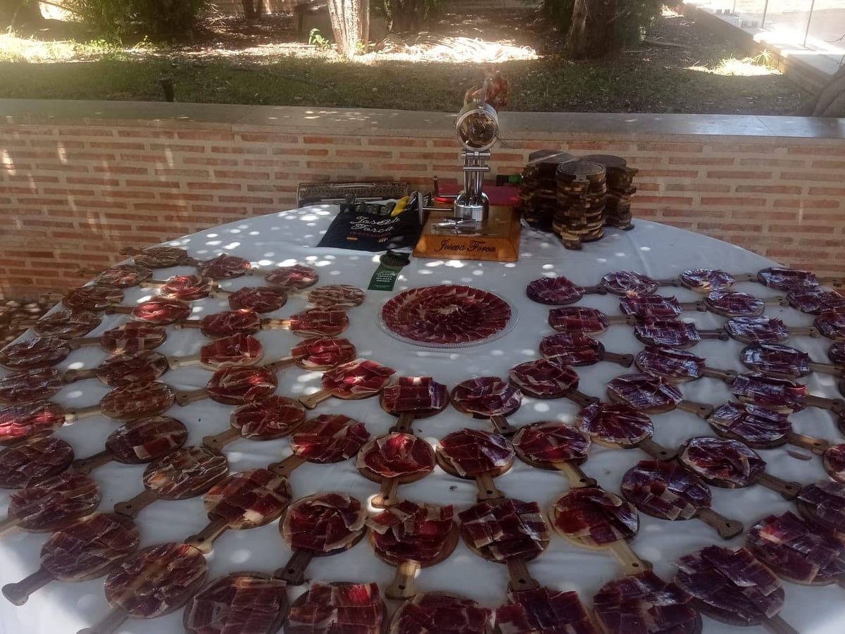 Mesa de evento con decenas de tablas individuales de jamón